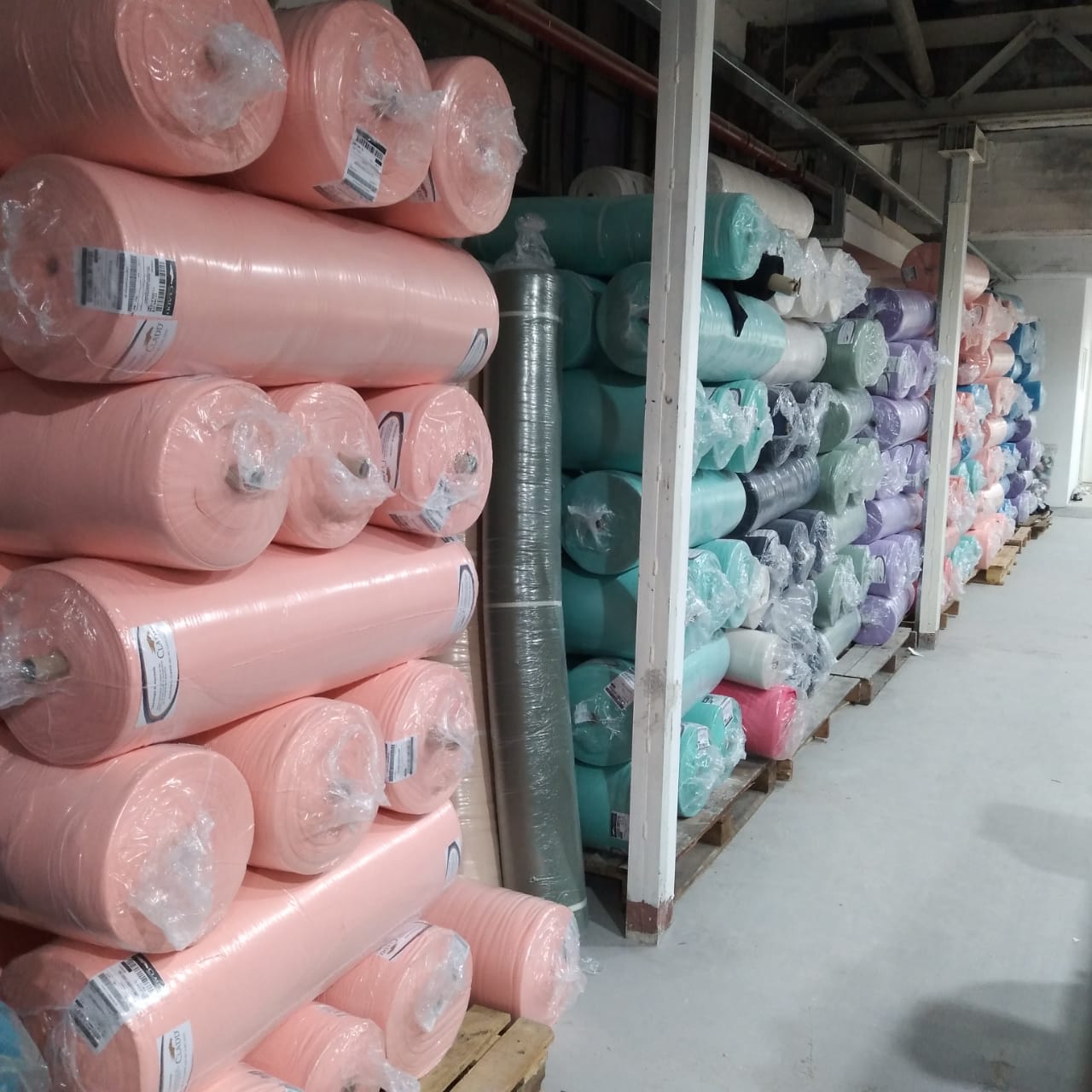 Rollos de tela organizados en depósito textil